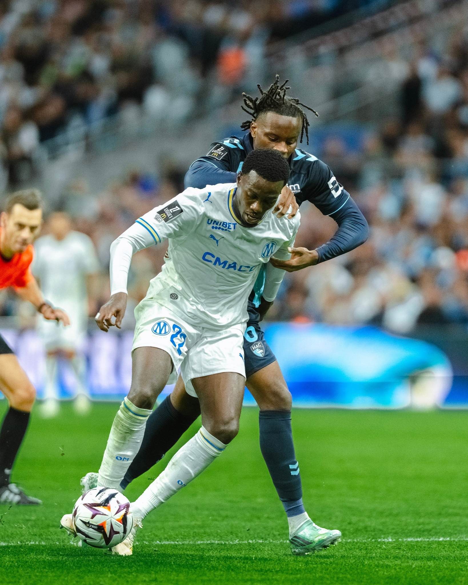 A Marseille player shields the ball under pressure from Le Havre.