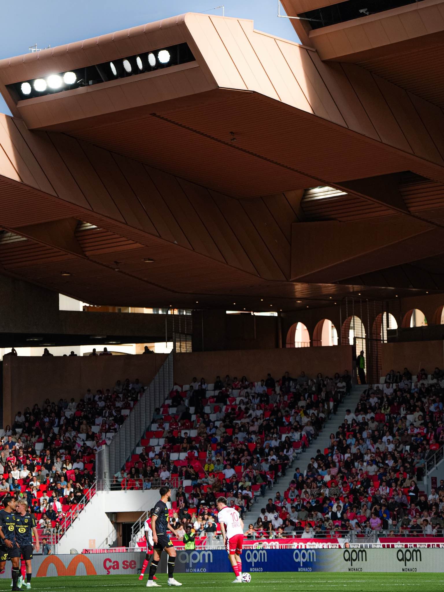 Monaco and Lille players compete in front of the packed crowd.