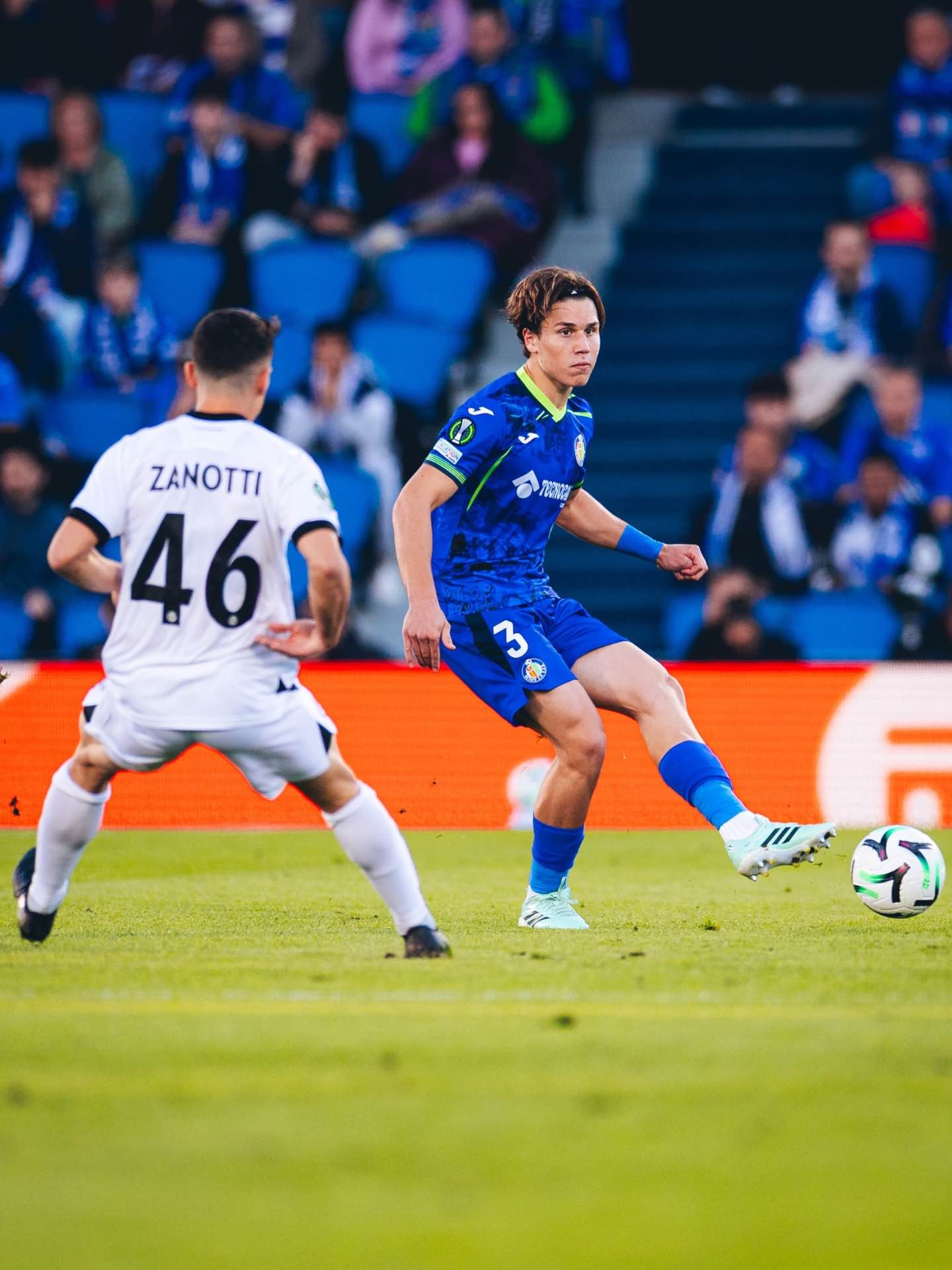 Getafe’s defender challenges Lugano’s attack during the match.