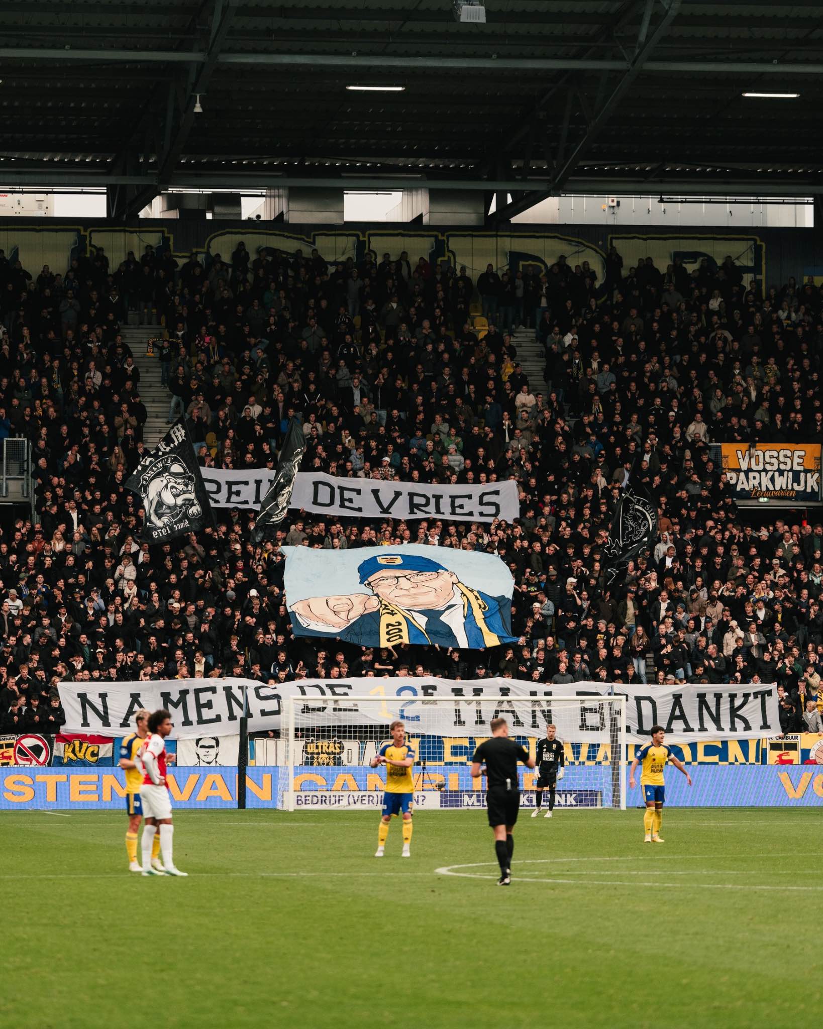 Supporters display flags and banners.